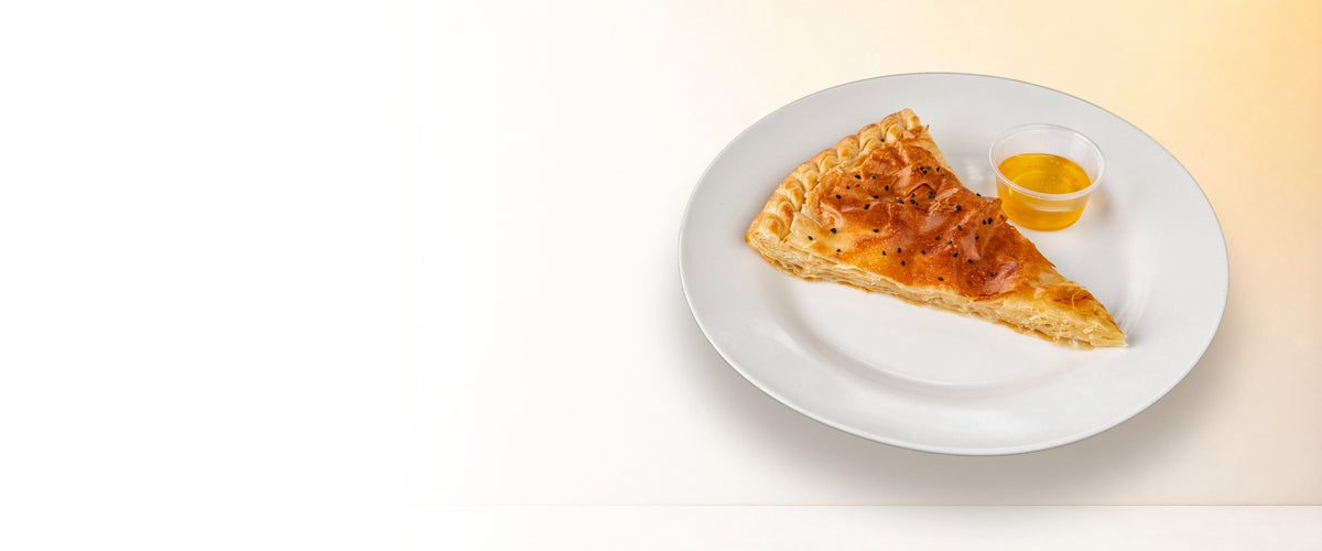 Golden Sabaya sabaya slice with honey on a white plate, warm white background