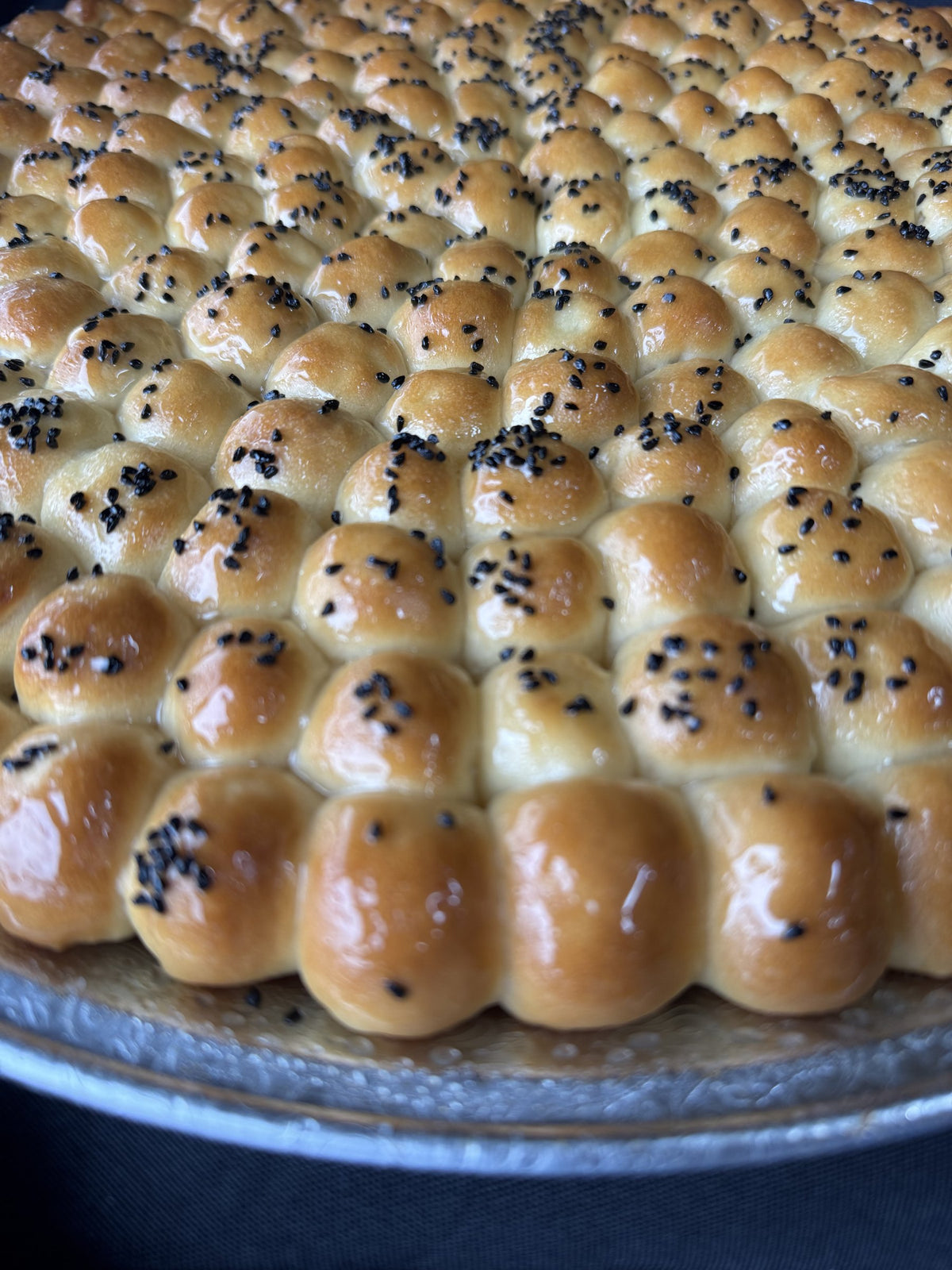 Close-up of Golden Sabaya honeycomb bread topped with black seeds