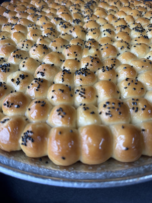 Close-up of Golden Sabaya honeycomb bread topped with black seeds
