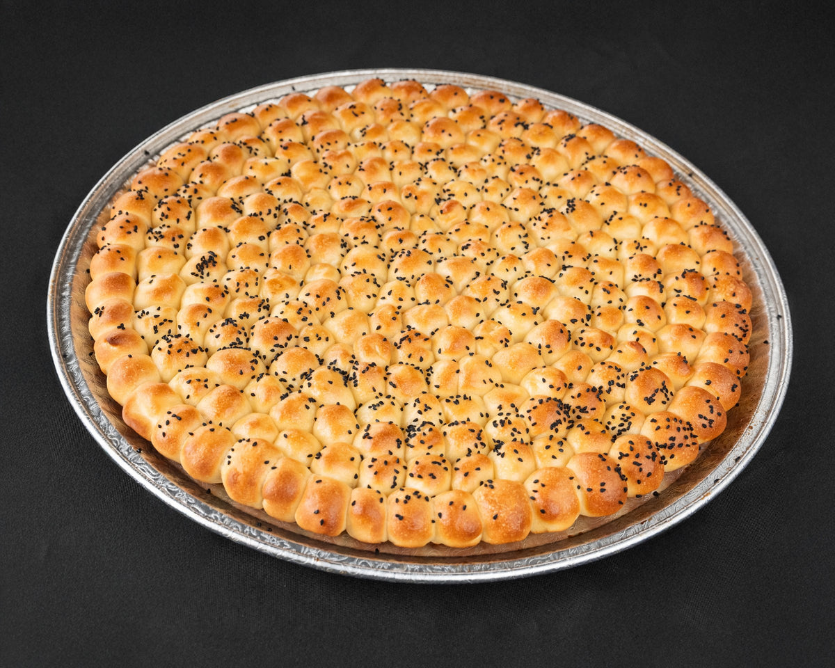 Golden Sabaya honeycomb bread on a round tray, white background