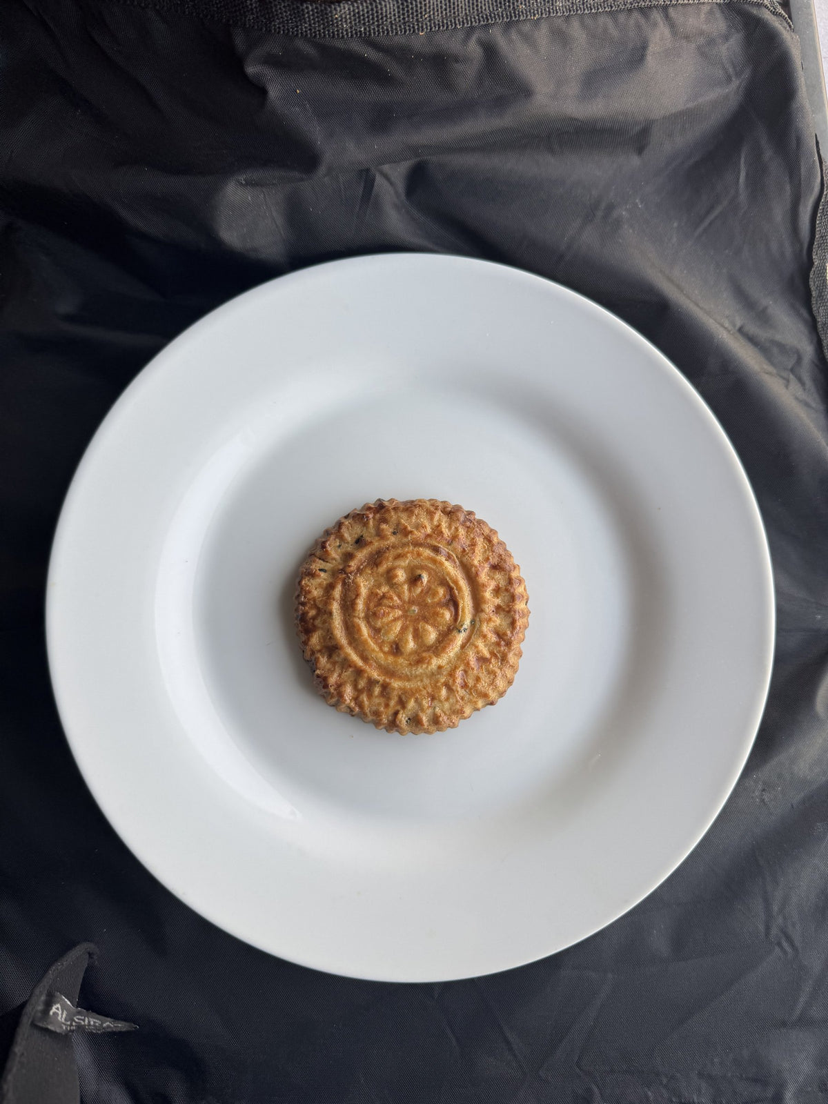 A single Yemeni kaak cookie on a white plate